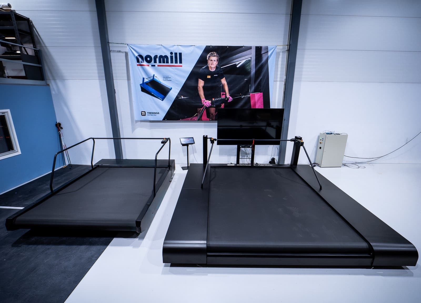 An XC-3000 and the larger XC-3300 standing side by side in the Normill showroom, showing the difference in belt size.